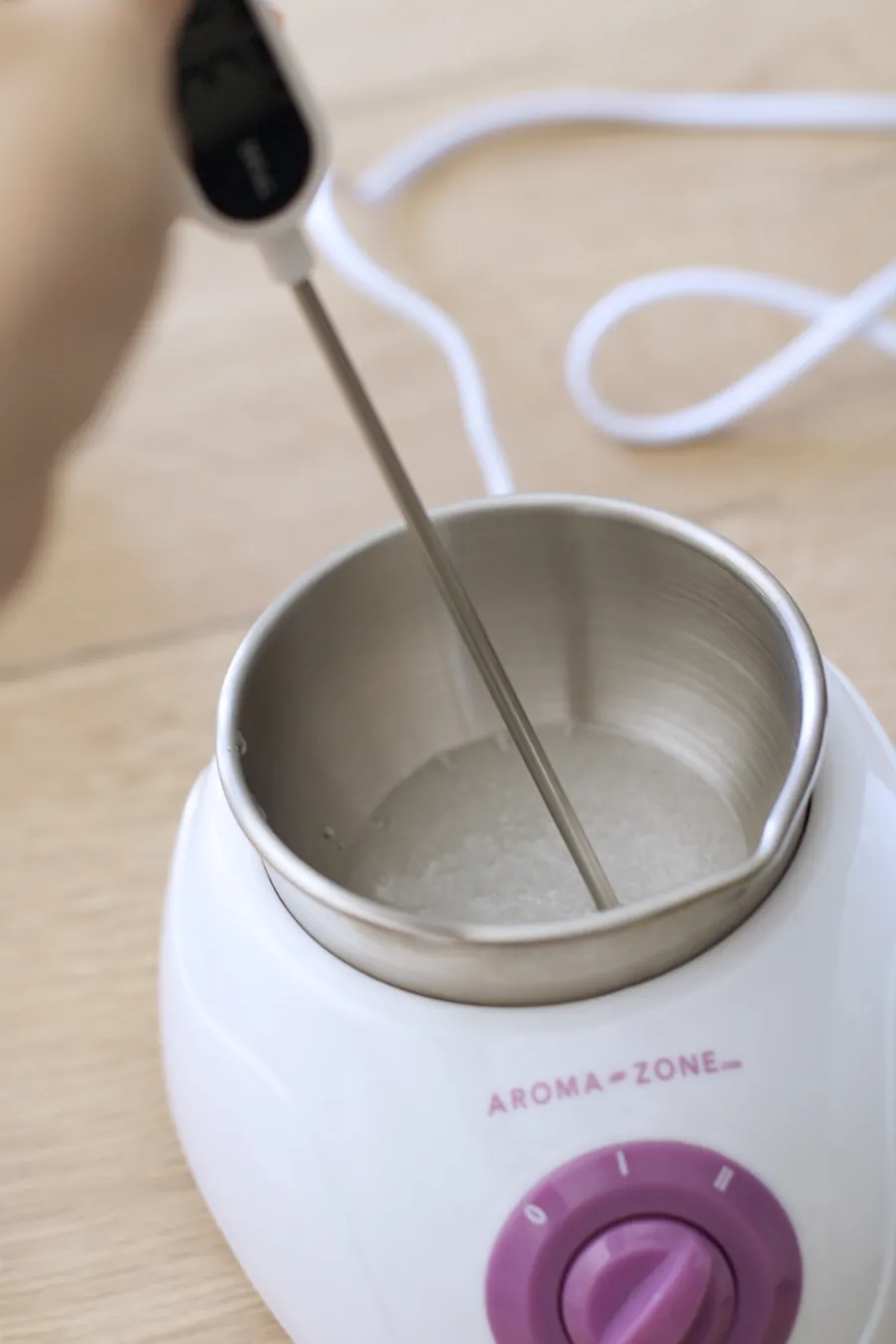 Un thermomètre plongé dans le bain-marie, la température relevée avant de verser