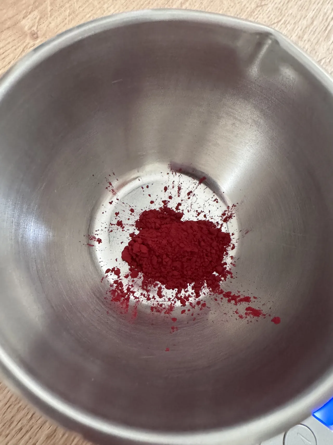 Un pigment rouge en poudre au fond d’un bol en inox