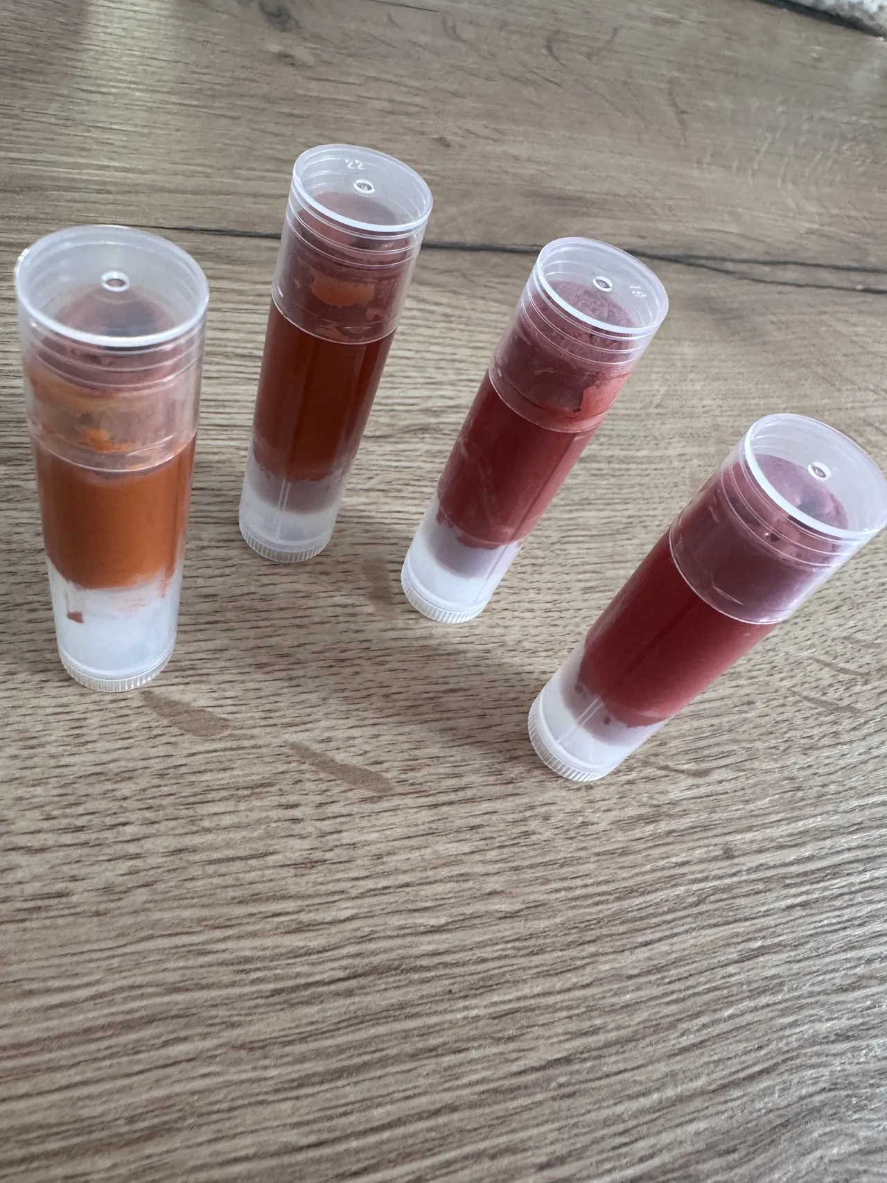 Quatre rouges à lèvres fabriqués en atelier, dans leurs sticks, du cuivré au bordeaux